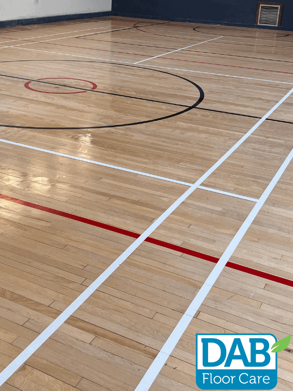 Polished wooden gym floor with markings.