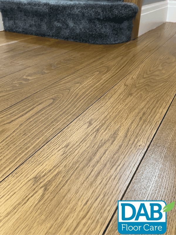 Polished oak floor with grey carpet.